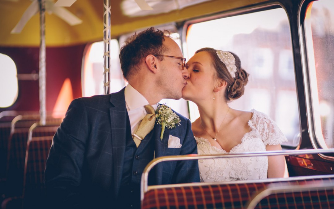 Bride and groom on routemaster kissing