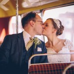 Bride and groom on routemaster kissing