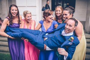 Bridesmaids lifting up groom