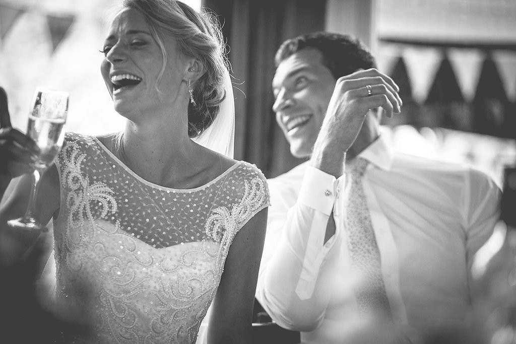 Bride and groom laughing at speech